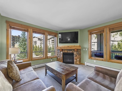 Open concept living room, featuring large windows allowing a lot of natural light in.