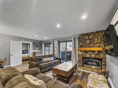 Open concept living space featuring fireplace and private balcony.