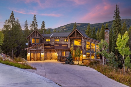 The mountain-style home features a large driveway, garage, multiple windows allowing ample natural light into the home.