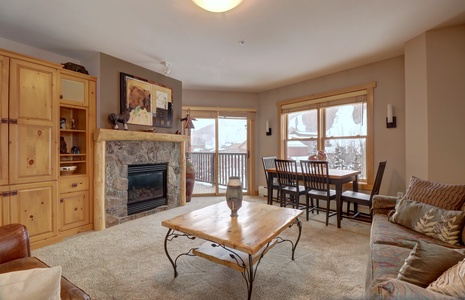 Cozy living area with fireplace, private balcony, and dining area.