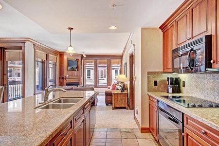 Beautiful kitchen with granite counter tops and an open concept looking out to living room.