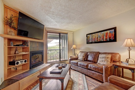 Cozy living room with a fireplace and patio door leading out to a small private balcony.