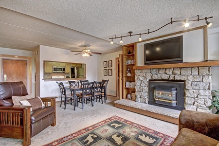 Open concept living and dining area with cozy fireplace.