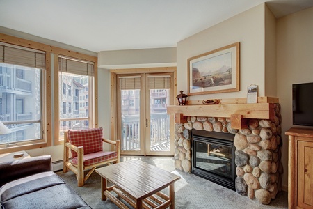 Cozy living room with fireplace and private balcony access.