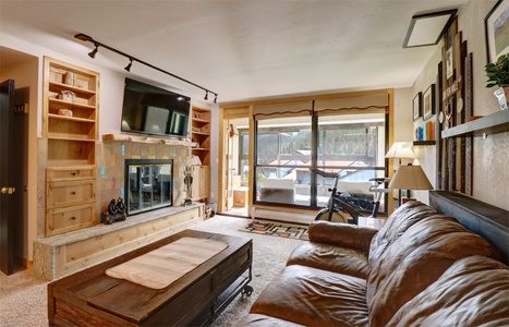 Living room features a wood burning fireplace and large windows for ample natural light.