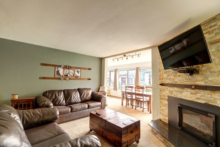 Living room area featuring a fireplace and large windows facing the mountain.