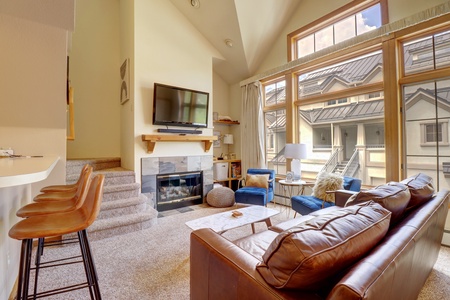 Open concept kitchen offers a fireplace with TV above.