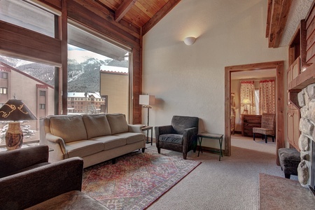 Living room features vaulted ceiling with large windows, great mountain views.