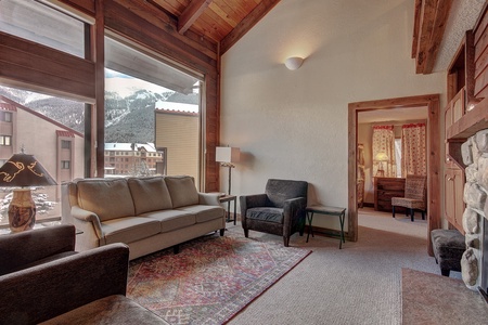 Living room features vaulted ceiling with large windows, great mountain views.