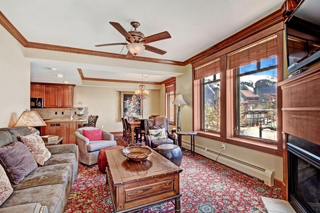 A vibrant living room featuring ample seating, large windows allowing natural light in.