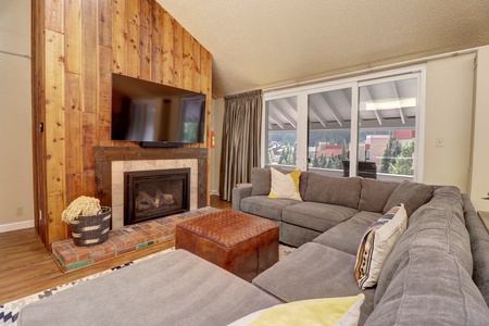 Living room features a large TV and fireplace.