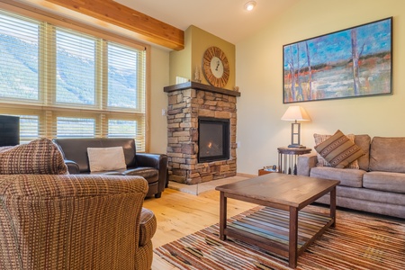 Cozy living room with nice fireplace and large windows allowing ample natural light in.