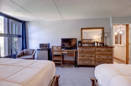 Hotel room features mini fridge, microwave, TV.