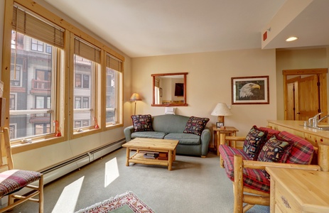 Main living area with large windows looking into Center Village