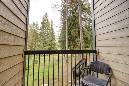 The balcony offers a couple chairs and great wooded views with mountains peaking through in the back.