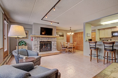 Living area with large TV and fireplace.