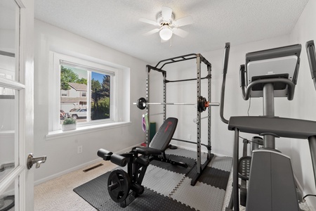 Home gym with bench press and olyptical