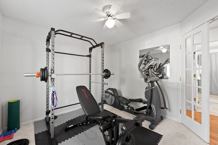 Home gym with bench press and olyptical