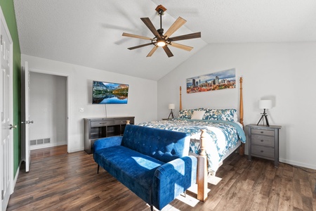 Primary bedroom, king size bed, couch and 55 inch flat screen smart TV