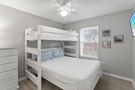 Family-friendly bedroom with a twin-over-full bunk bed, soft carpeting, and coastal accents—perfect for kids or extra guests.