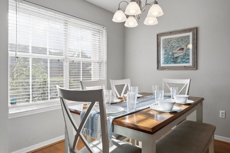 Bright and airy dining area with seating for six, coastal décor, and natural light—perfect for shared meals and conversation.