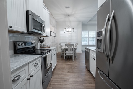 Kitchen with white cabinets and modern stainless steel appliances.