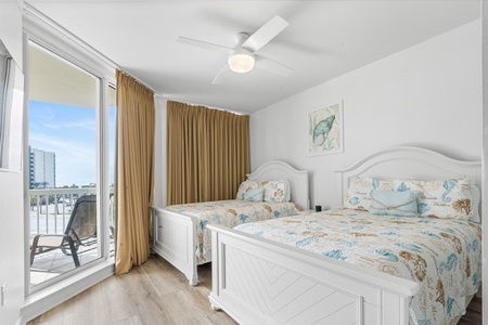 Guest bedroom with 2 full-size beds with balcony access.