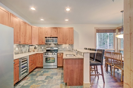 The kitchen features granite counter-tops and stainless steel appliances. 