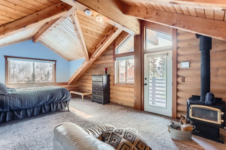 Fireside Comfort - A Vaulted Cabin Bedroom with Private Balcony