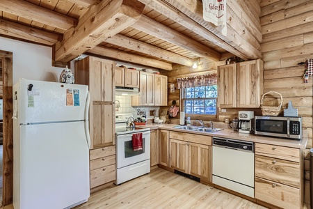 A kitchen in a log cabin with a stove and refrigerator.