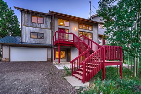 A home with a red staircase in the woods.