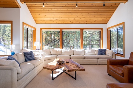 Seat your entire family in this living room featuring comfy furnishings, light and warmth from skylights and stunning views from large wall of windows