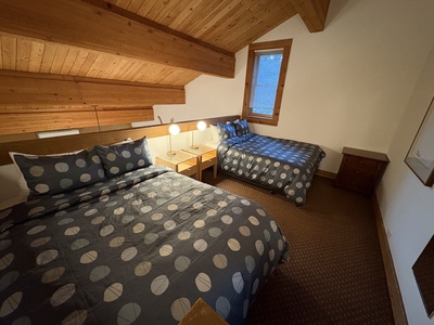 Comfort and space come together in this open loft bedroom, featuring two queen beds, new nightstands, a stylish dresser, and a spacious closet for all your essentials.