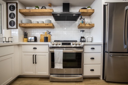 Modern kitchen with stainless steel appliances, and a cozy design, perfect for preparing meals at home during your stay.