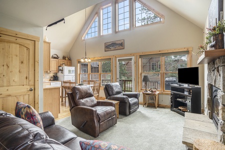 Living room with 2 leather recliners, flat screen tv, fireplace and couch.