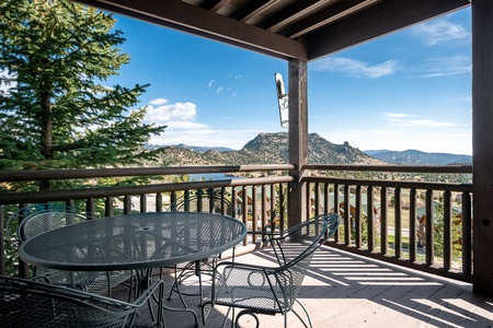 Patio seating for four guests on the condo's deck, surrounded by beautiful mountain views.