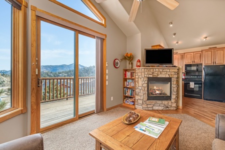 Open concept between living room and kitchen with a fireplace and flat screen TV. With beautiful view from the deck. 