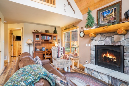 Living room with fireplace, desk, leather couch, and arm chair.