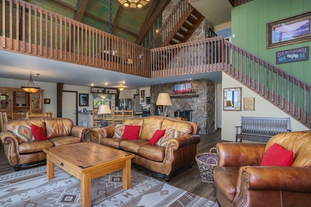 Living Room with a sofa, loveseat, overstuffed couch and a loft above 14 stairs to each loft area