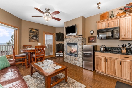 Living/dining area with queen sleeper sofa and bar-height dining table (seating for four), gorgeous stone gas fireplace. Opens up to efficiency kitchen.