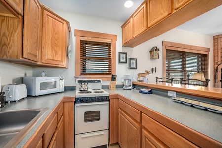 Cozy kitchen fully equipped to meet your vacation meal preparation needs. Oven, stovetop, microwave, toaster, dishwasher, full size refrigerator, tea kettle, and drip coffee maker.