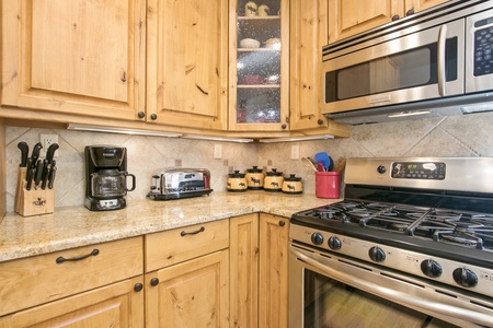 The kitchen has beautiful appliances with gas stove/oven, microwave and drip coffee maker.