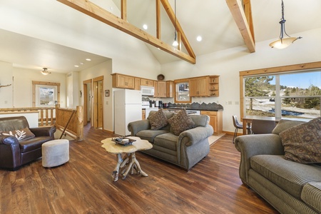 Main level living area with two double-cushion sofas, a loveseat, and vaulted ceilings. Beautiful mountain views from large floor to ceiling windows.