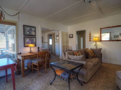 View of the cozy living area that has a desk, couch and overstuffed chair