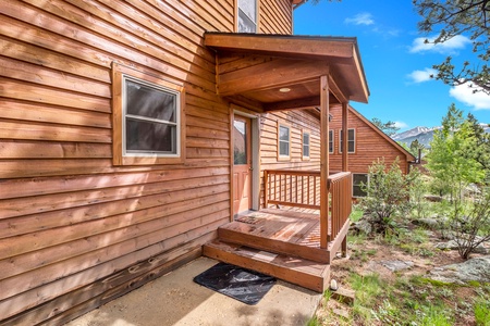 Exterior of cabin, front door with small covered porch.