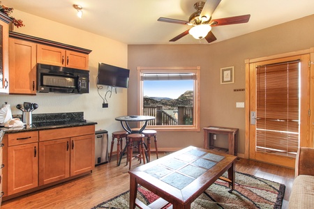 Window in the cozy combo kitchen/dining area opens up to breathtaking mountain views to be enjoyed from the bar-height dining table with seating for four.