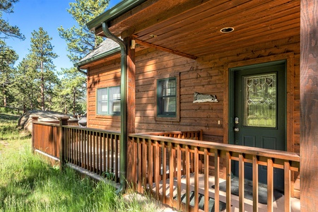 Exterior of cabin with front door and small porch.