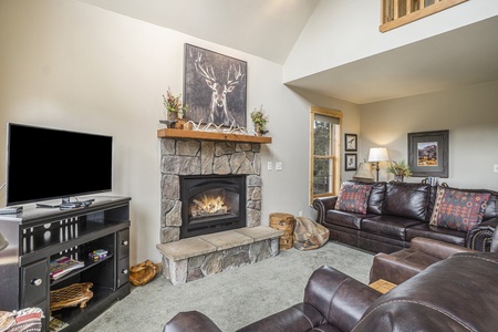 Living room with 2 leather recliners, flat screen tv, fireplace and leather couch that seats 4.