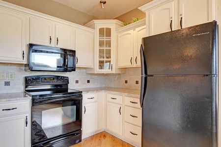 Full kitchen with refrigerator, glass top stove/oven, microwave.