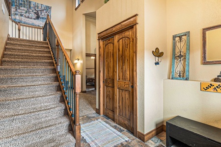 Timber Mountain Retreat Estes Park, Entryway into the home, carpeted stairs up to main living/dining area.